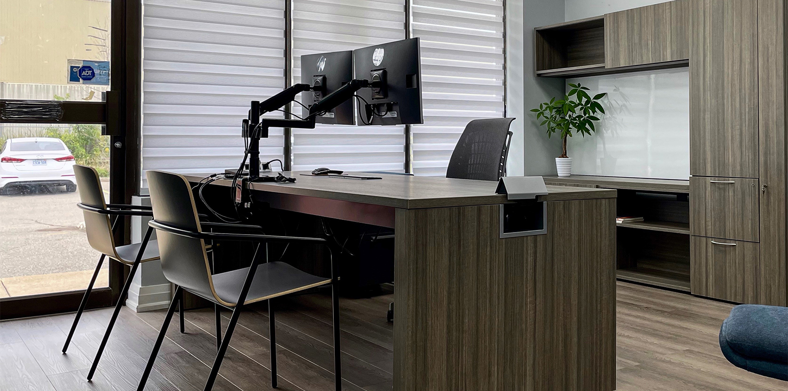 Desk with dual monitors and two chairs in front