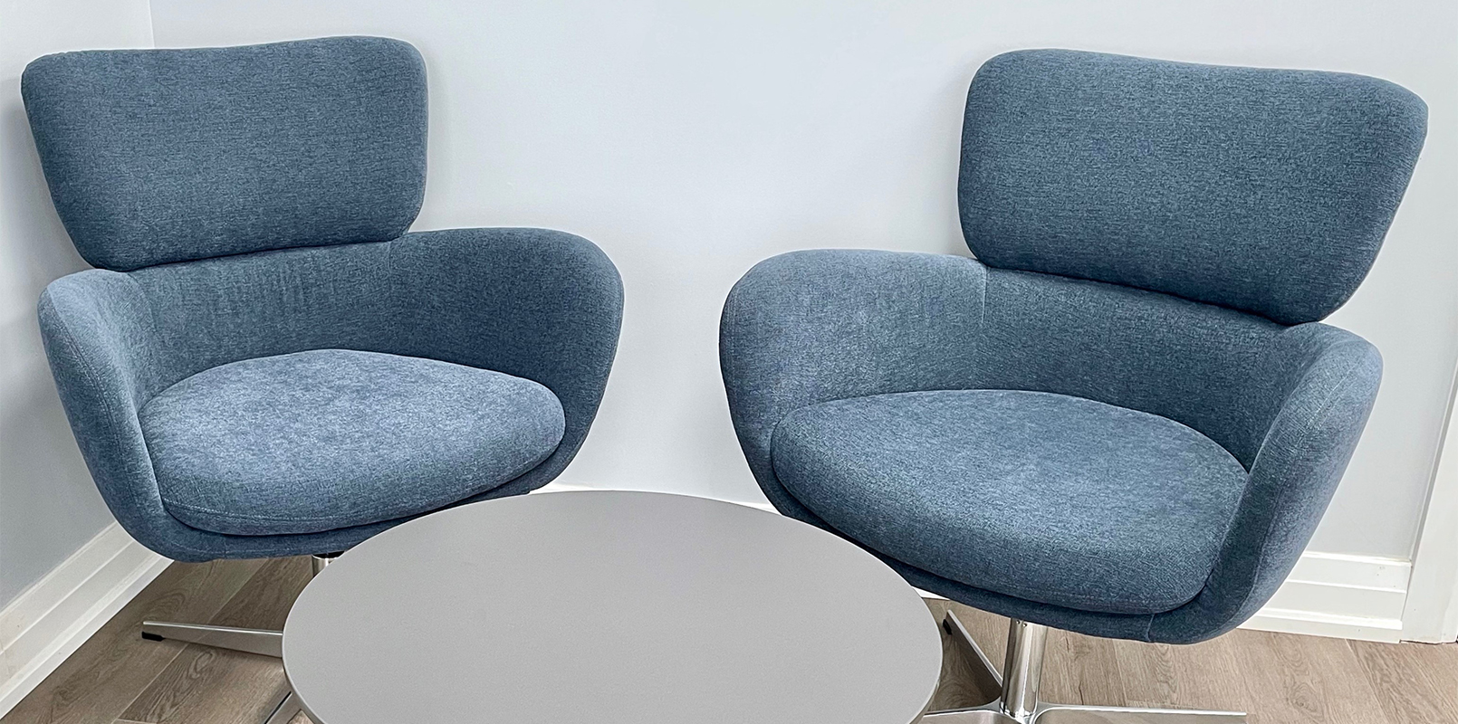 Two blue fabric accent chairs with round table